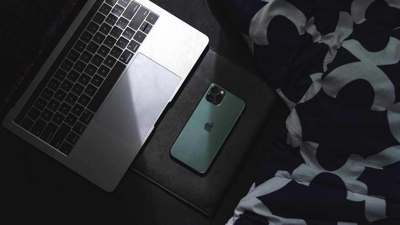 A sleek laptop and smartphone resting together. Ideal for technology and lifestyle themes.